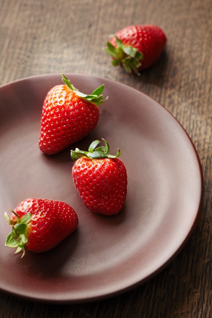Fresh strawberries on brown ceramic plate