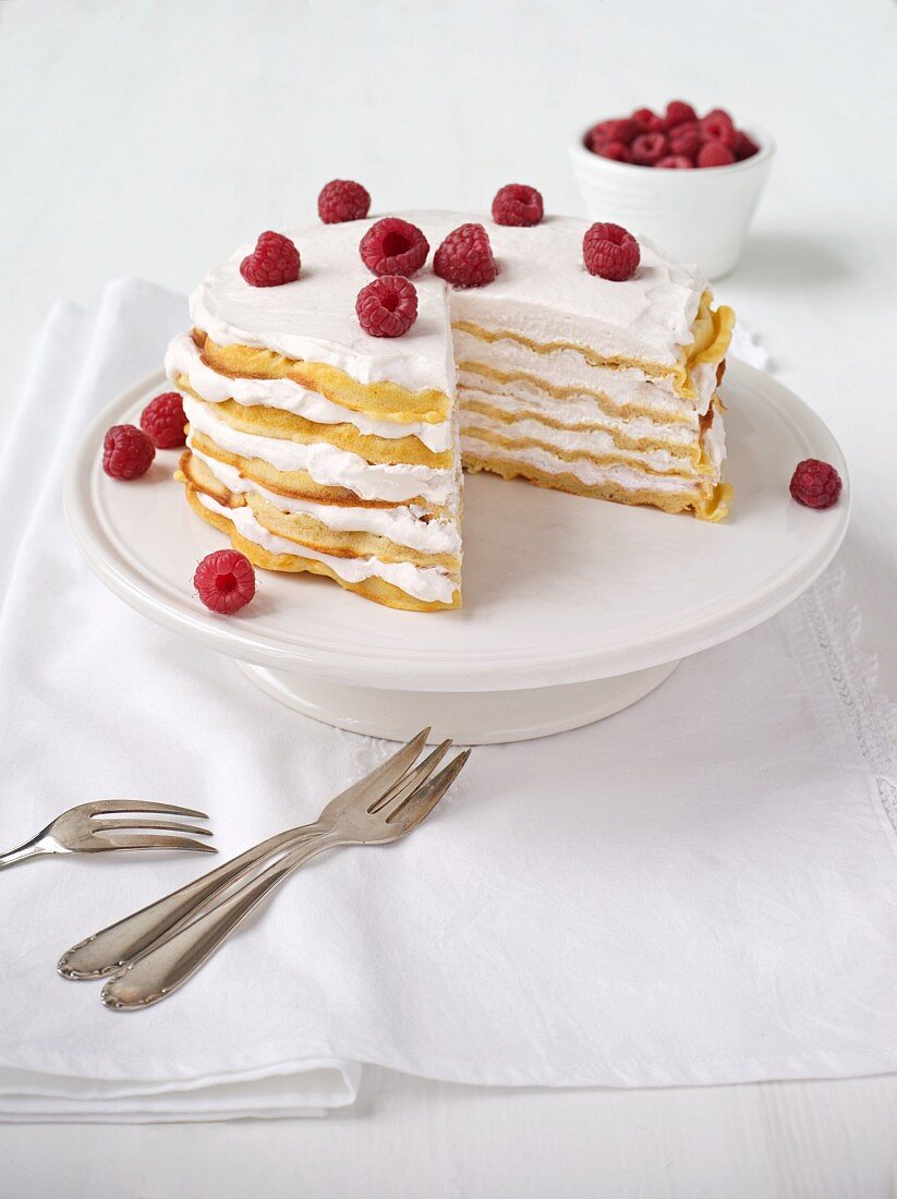 Waffle layer cake with raspberries, one slice removed