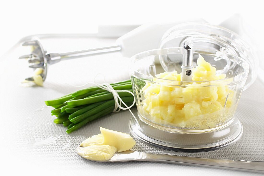Mashed potato in a mixer, butter and green beans