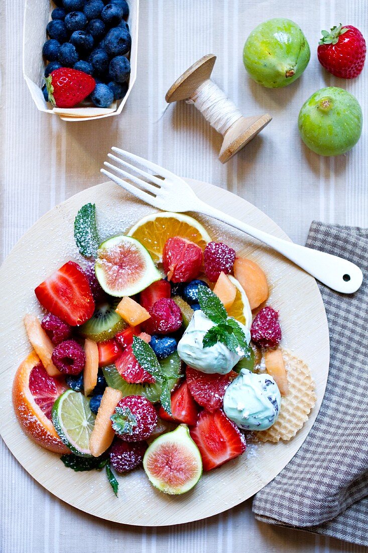 A large fruit salad with mint ice cream