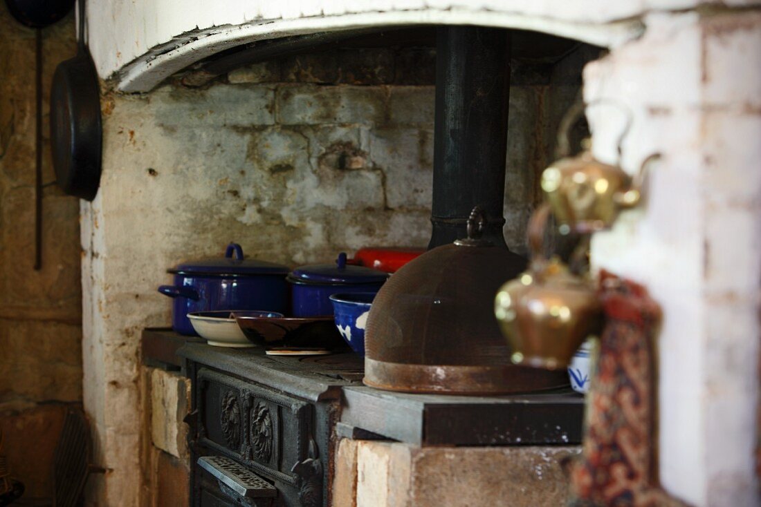 Blue enamel cooking pots on a rustic stove in a simple country house