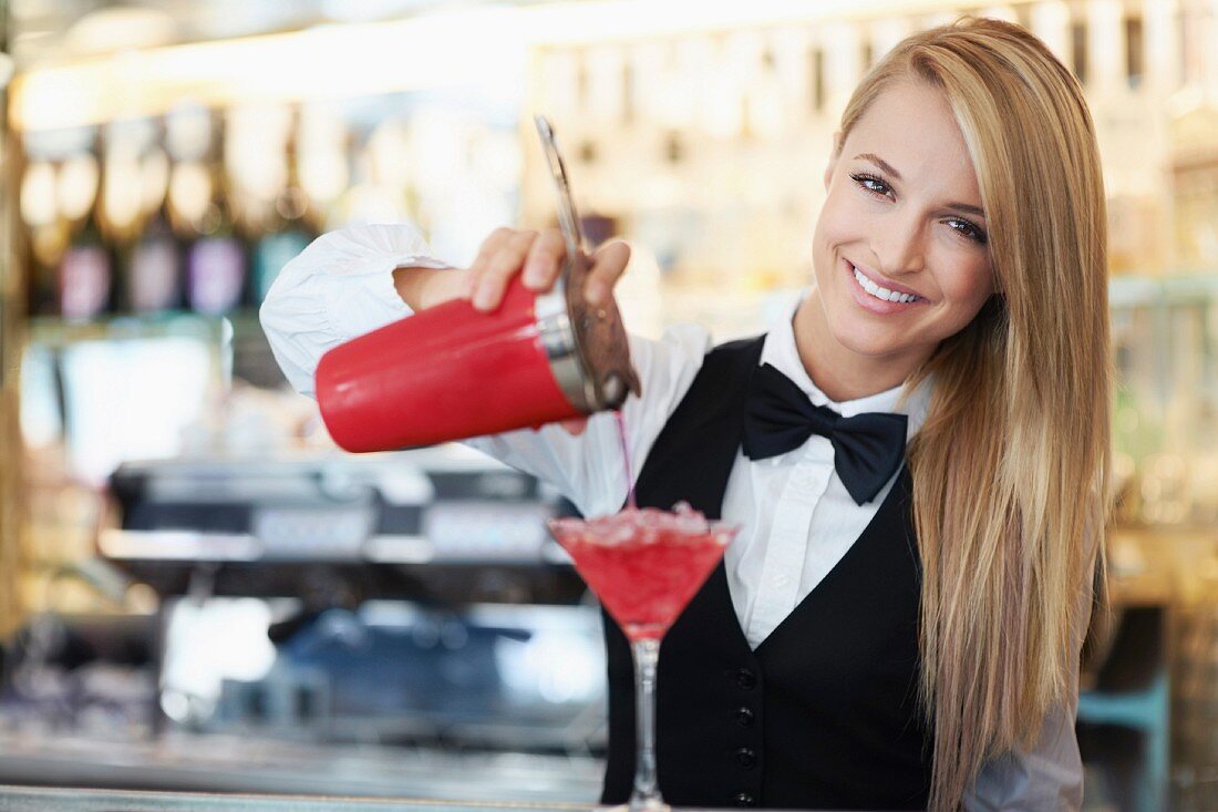 Kellnerin mixt Cocktail im Restaurant