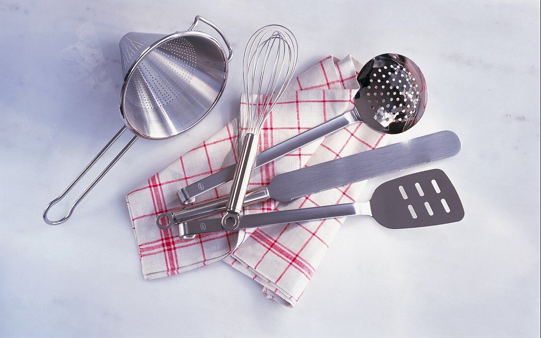 Assorted kitchen utensils on a tea towel