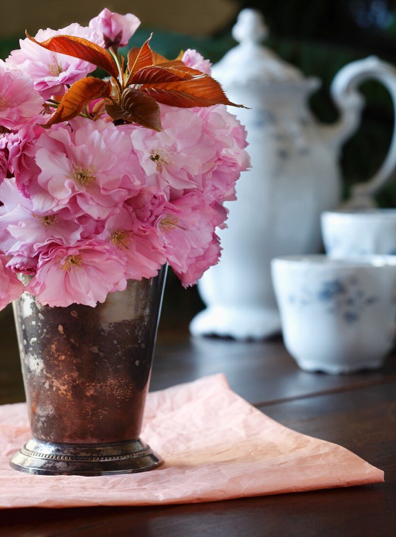 Cherry Blossoms in a Vase with Antique Tea Setting in Background