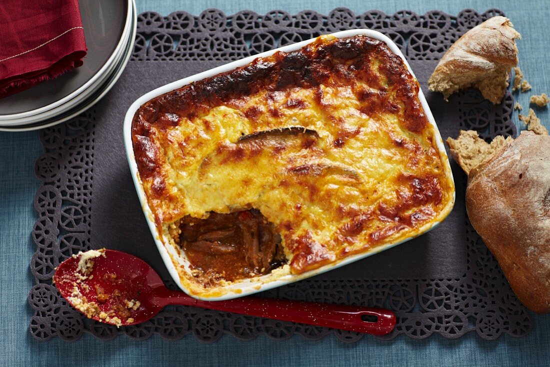 Cheese-topped, baked beef ragout with bread