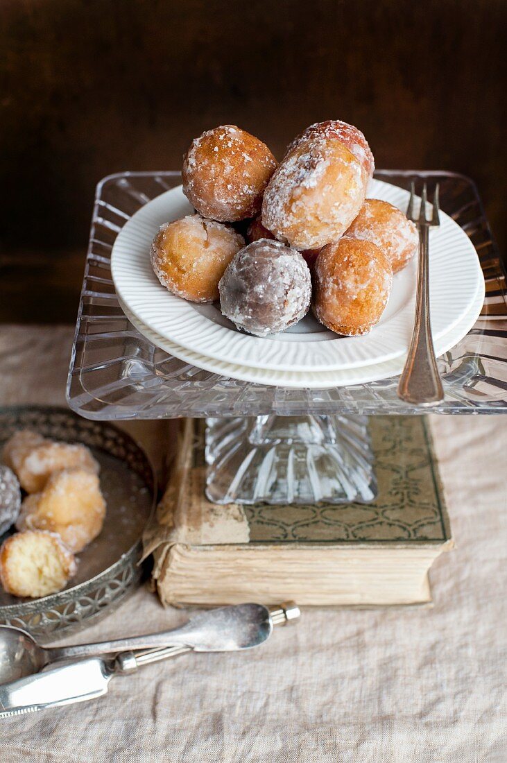 Doughnuts on a cake stand on top of an old book
