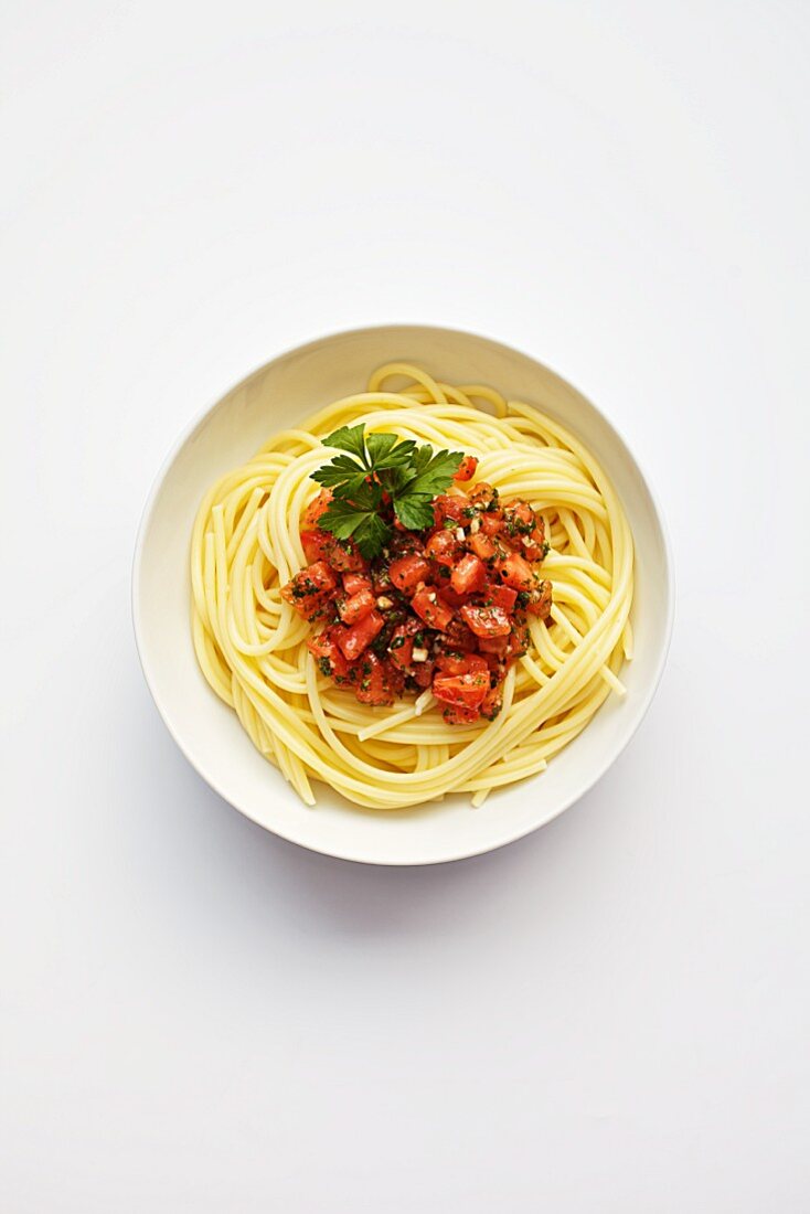 Spaghetti with cold tomatoes, parsley and garlic