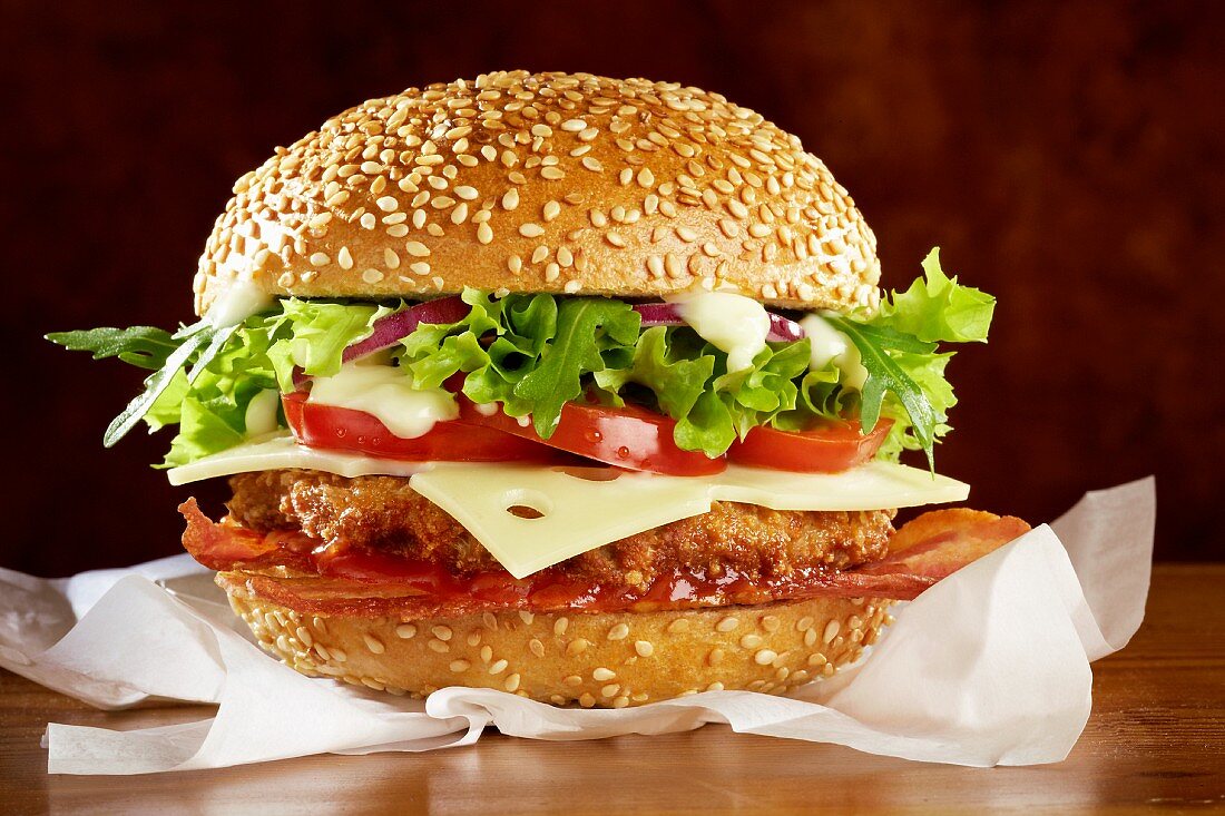 A hamburger with bacon, cheese and lettuce