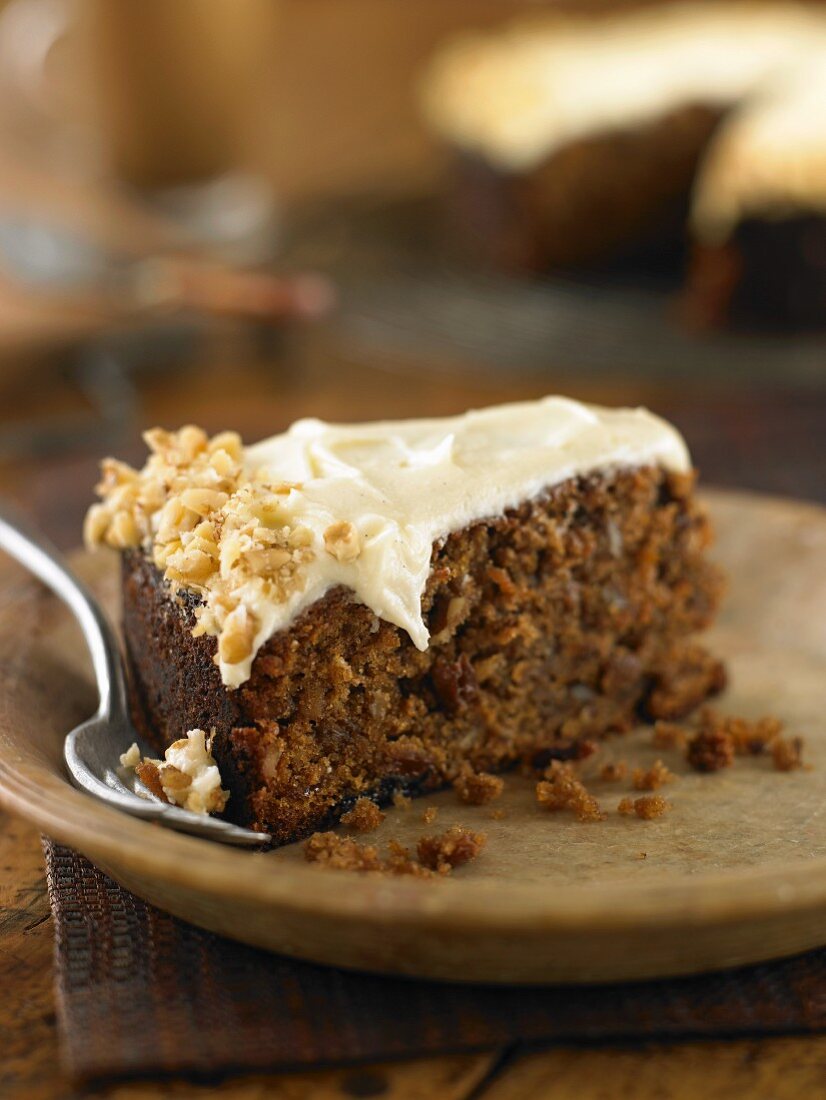 A piece of carrot cake topped with nuts