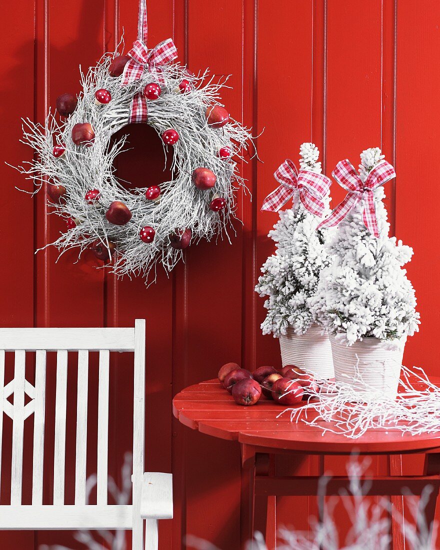 Winter wreath and miniature Christmas trees on terrace