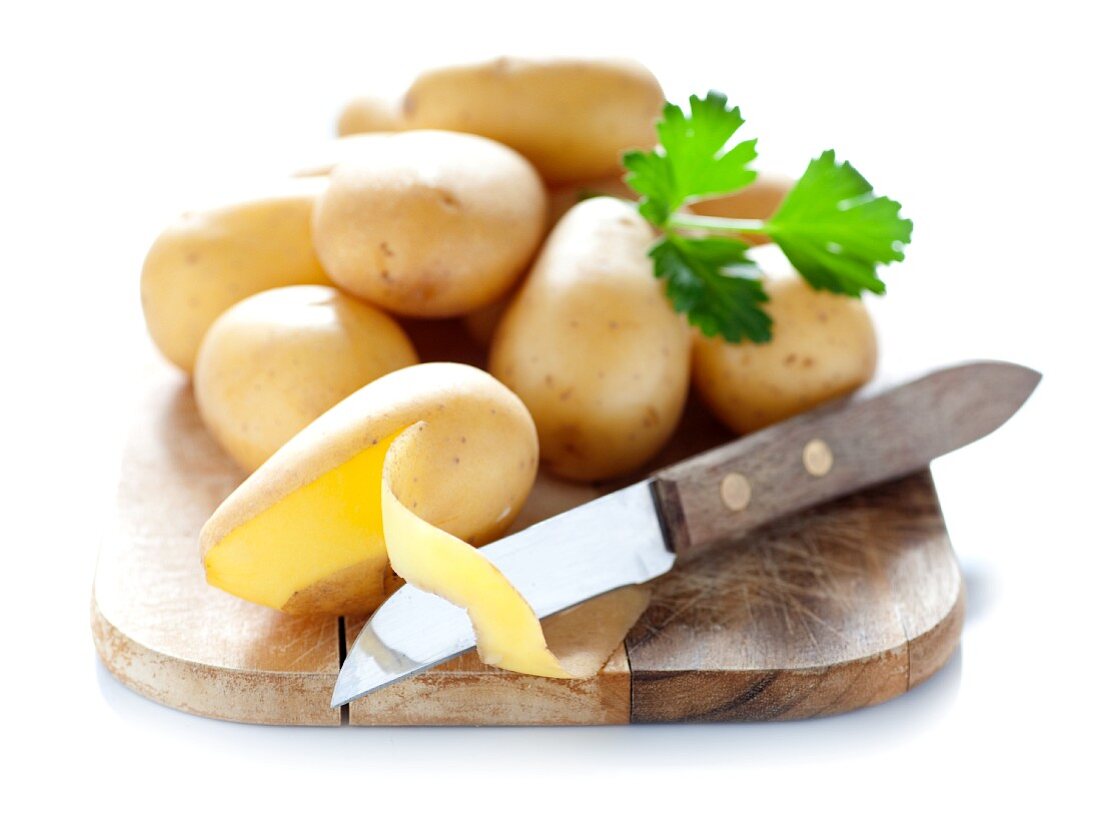 Potatoes on a chopping board with a knife