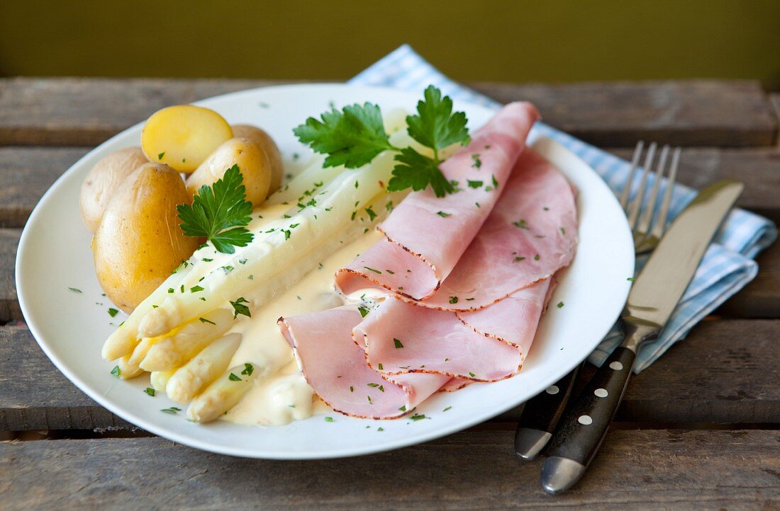 White asparagus and boiled ham with Hollandaise sauce and potatoes