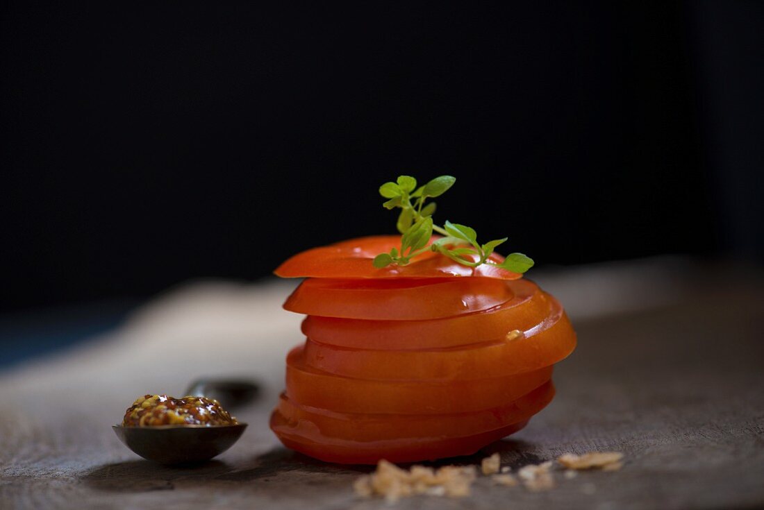 Sliced tomato with mustard, curing salt and Greek basil