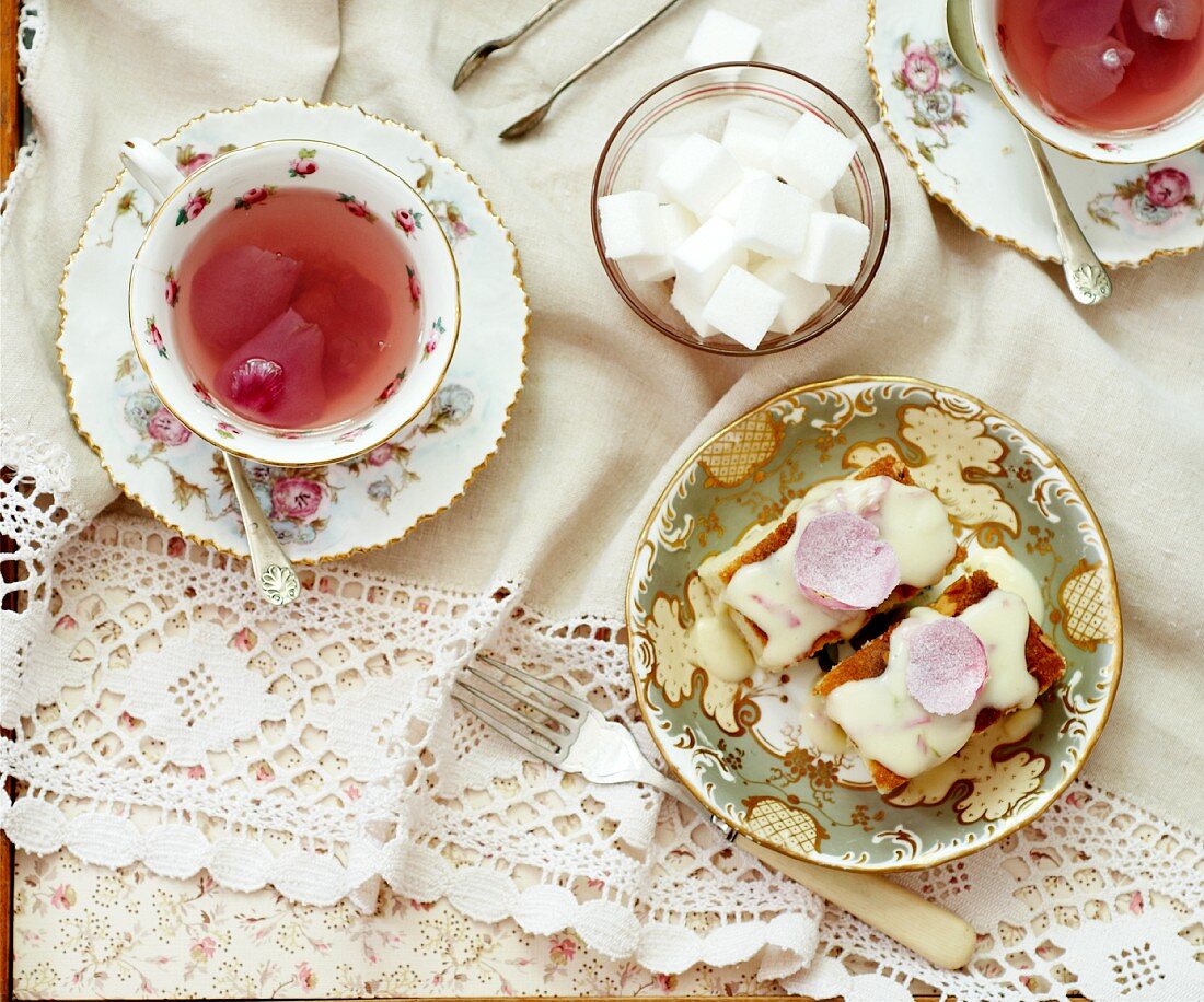 Mandelkuchen mit Rosenblüten und Zuckerguss, Rosentee, Zuckerwürfel