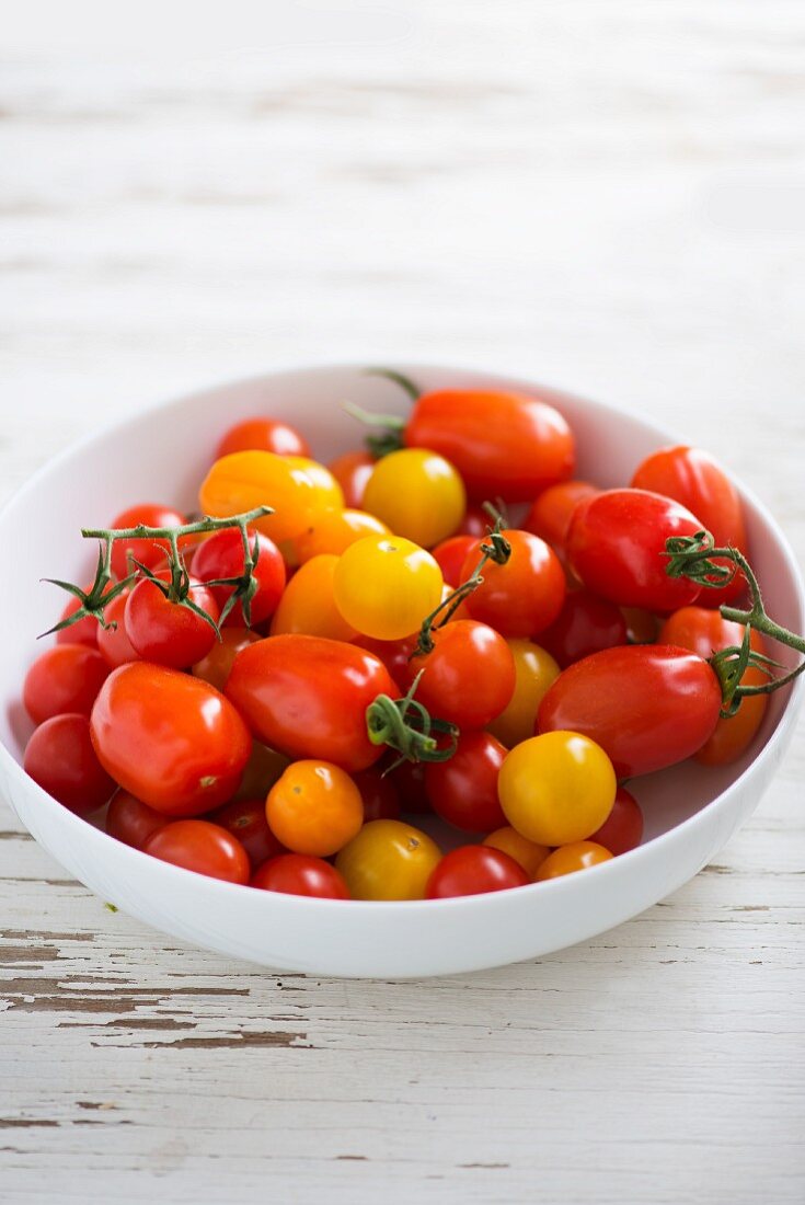 Red, yellow and orange tomatoes in a white dish