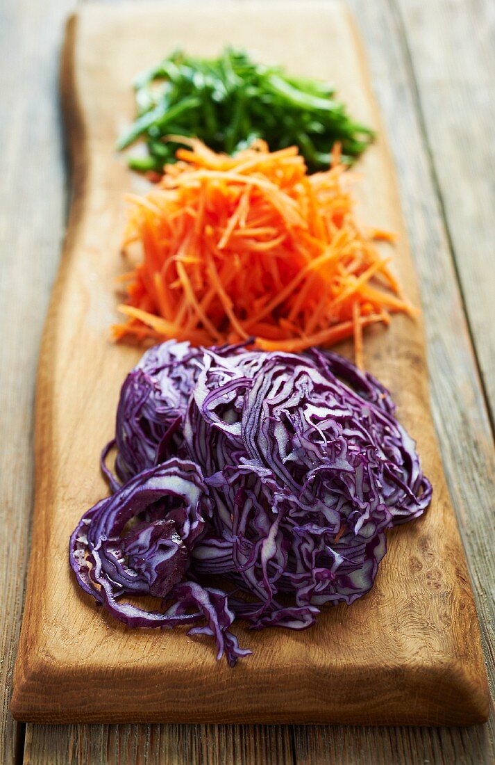 Red cabbage and carrots (grated) on a wooden board