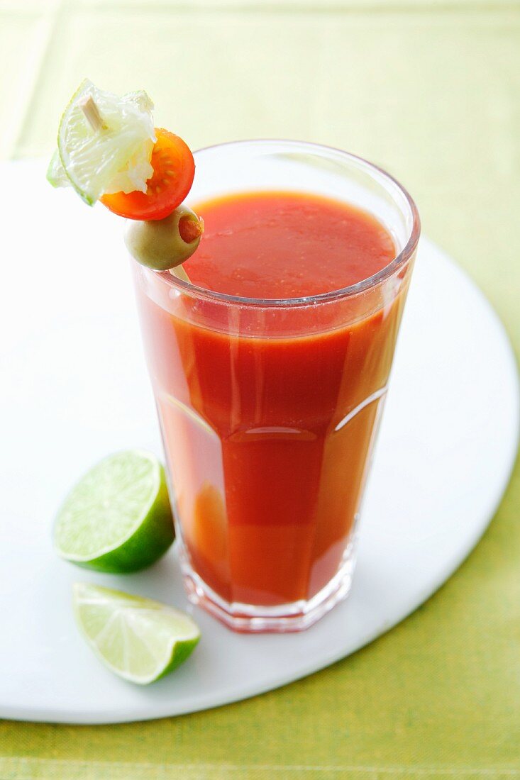 A glass of tomato juice with a vegetable skewer