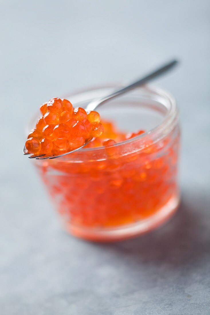 Salmon caviar in a jar with a spoon