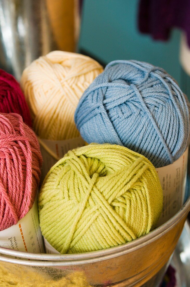 Balls of wool of different colours in tin