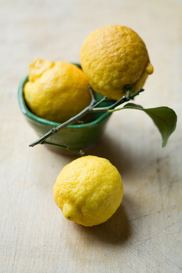 Drei Zitronen mit Stiel und Blättern