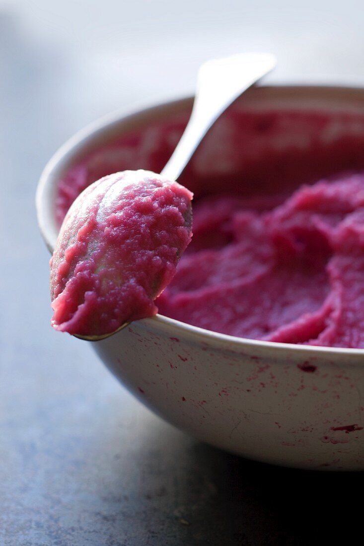 Beetroot purée in a bowl with a spoon