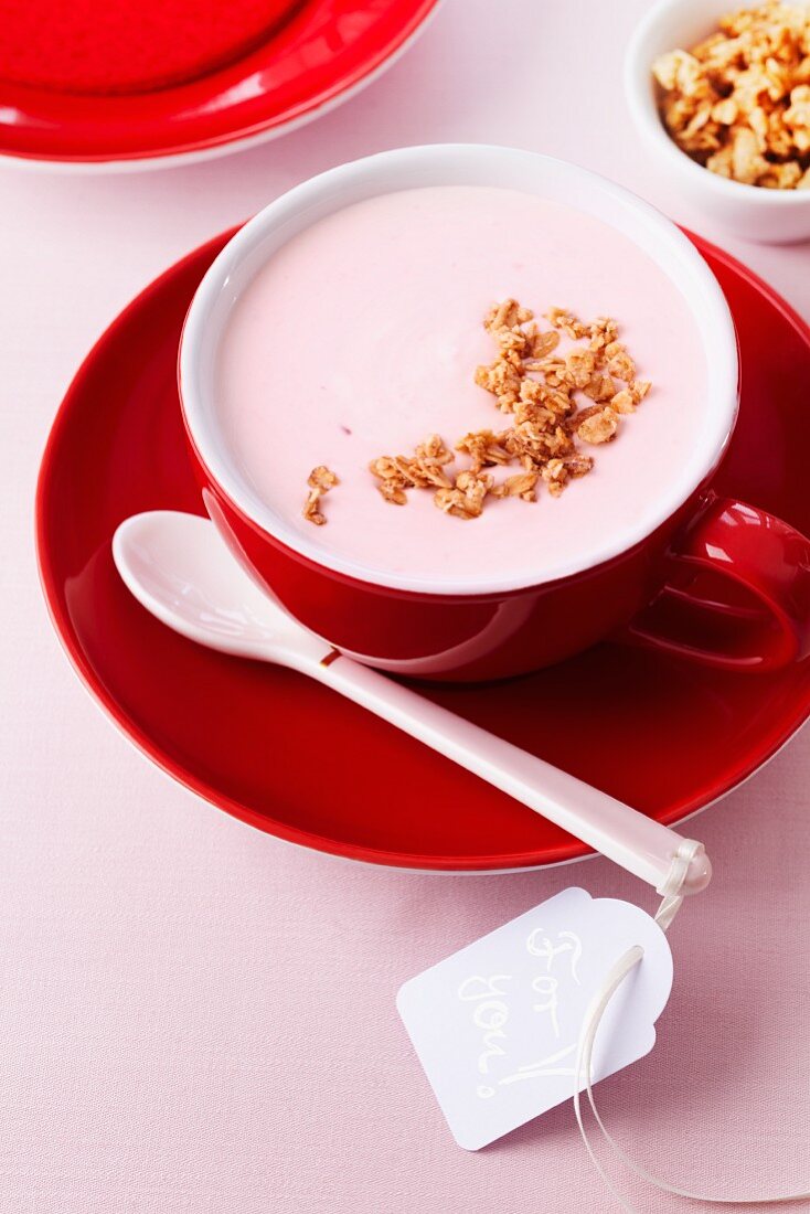 Joghurt mit Müsli in roter Tasse mit Liebesbotschaft