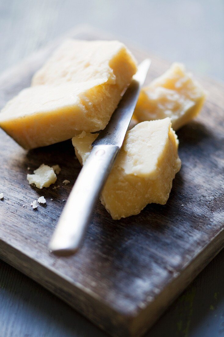 Parmesan with a knife on a chopping board