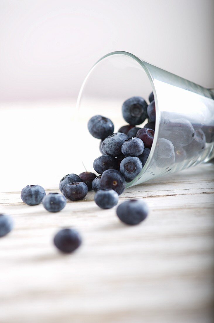 Lots of blueberries in an overturned glass