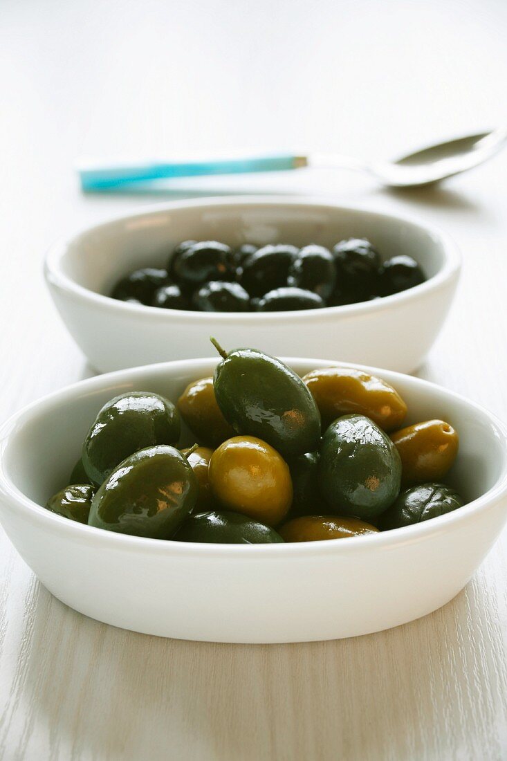 Schwarze und grüne Oliven in Schalen