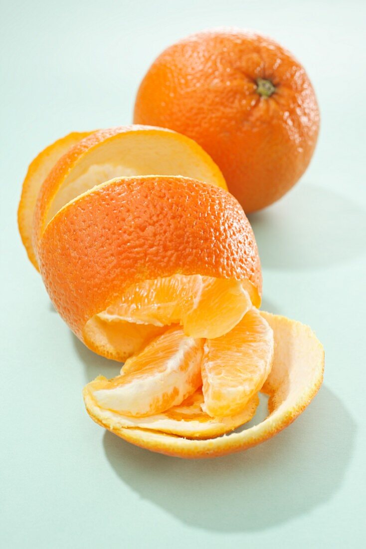 A whole orange, orange peel and orange segments