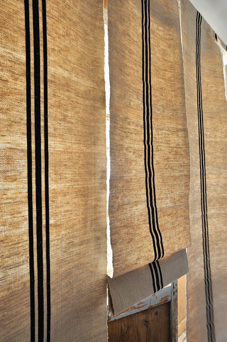 Closed Roman blinds with black stripes on windows