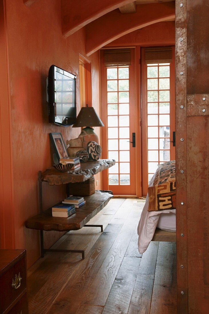 Console shelves made from live-edge wood in salmon pink corridor with lattice doors