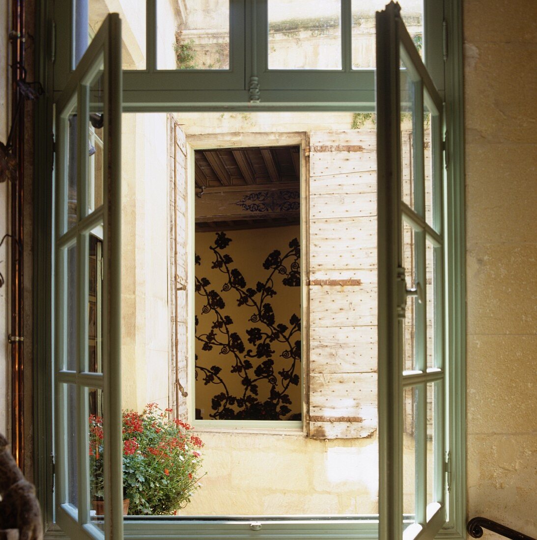 View from a window above the courtyard of an old South African town home into a window opposite