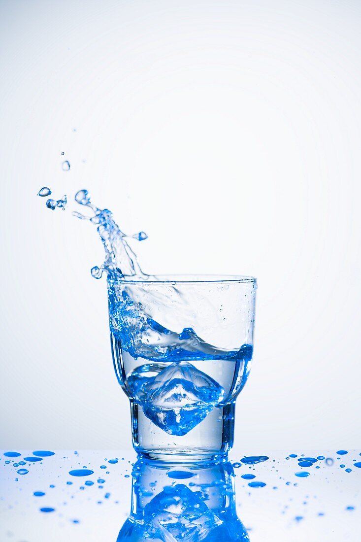 Wasser spritzt aus Glas