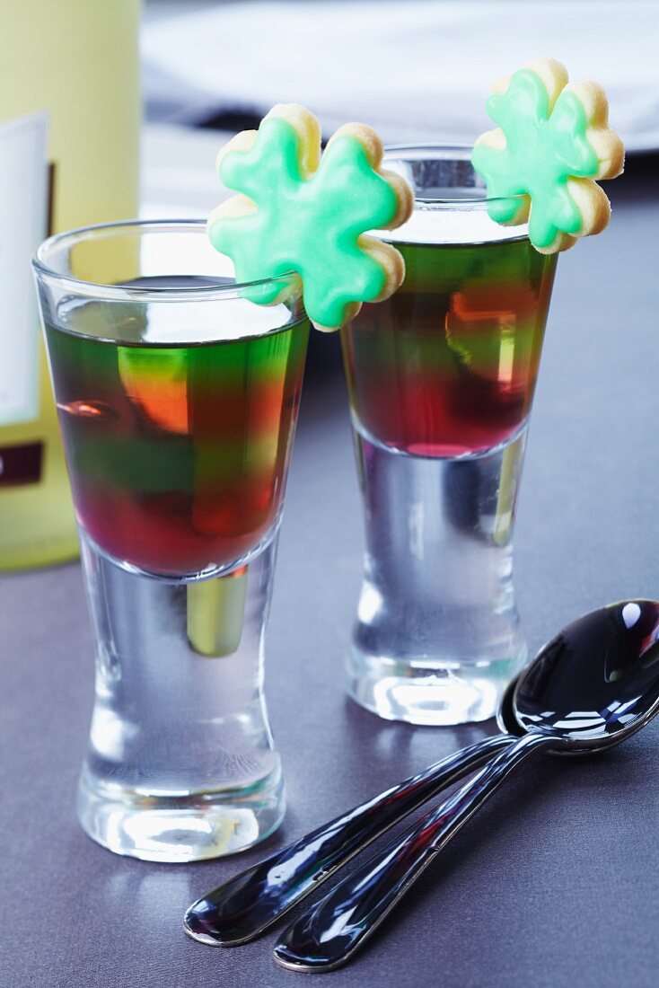 Layered jelly in glasses decorated with clover leaf-shaped biscuits