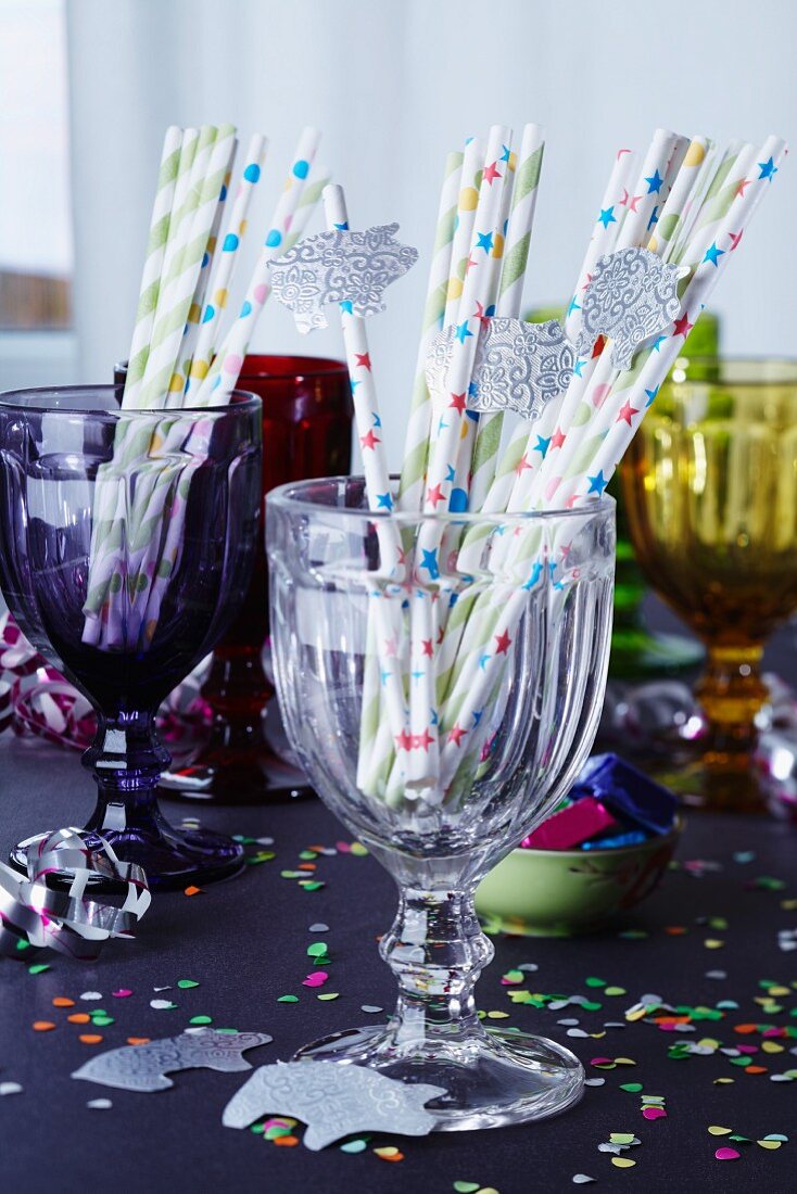 Straws decorated with lucky pigs in glass on a table laid for a party