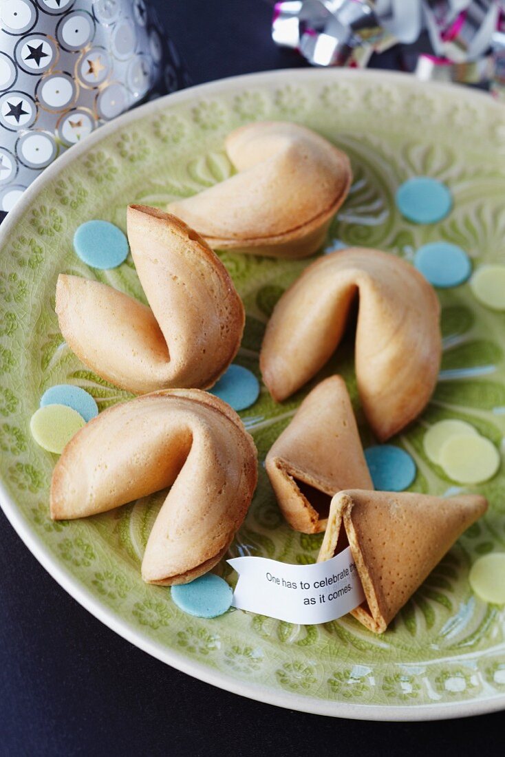 Fortune cookies with rice paper confetti on a plate