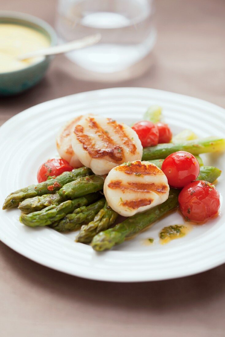 Grilled scallops on asparagus with cherry tomatoes