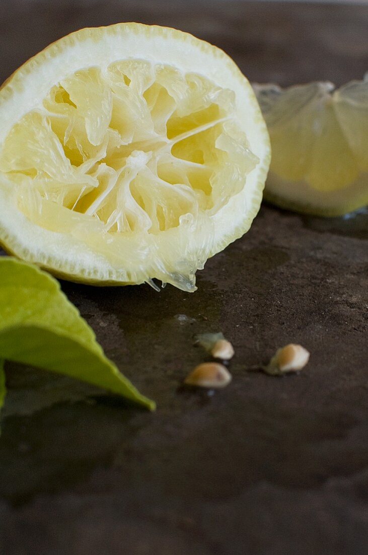 A squeezed lemon half and lemon seeds