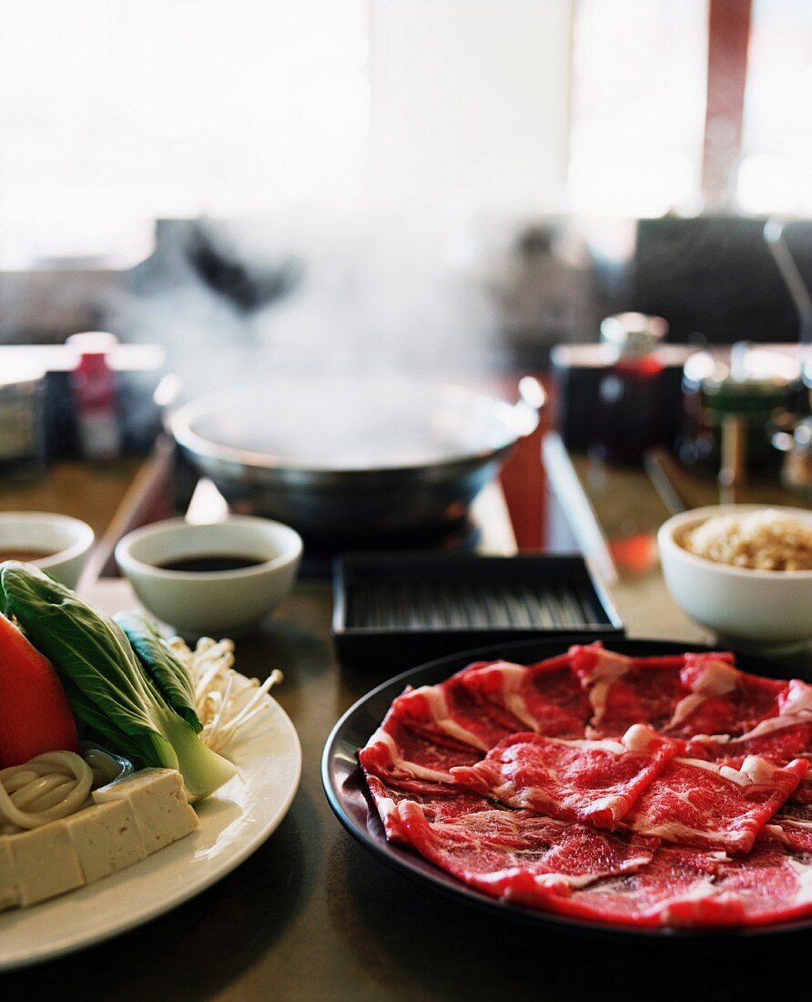 Rindfleisch, Gemüse und Tofu vor dem dampfenden Wok