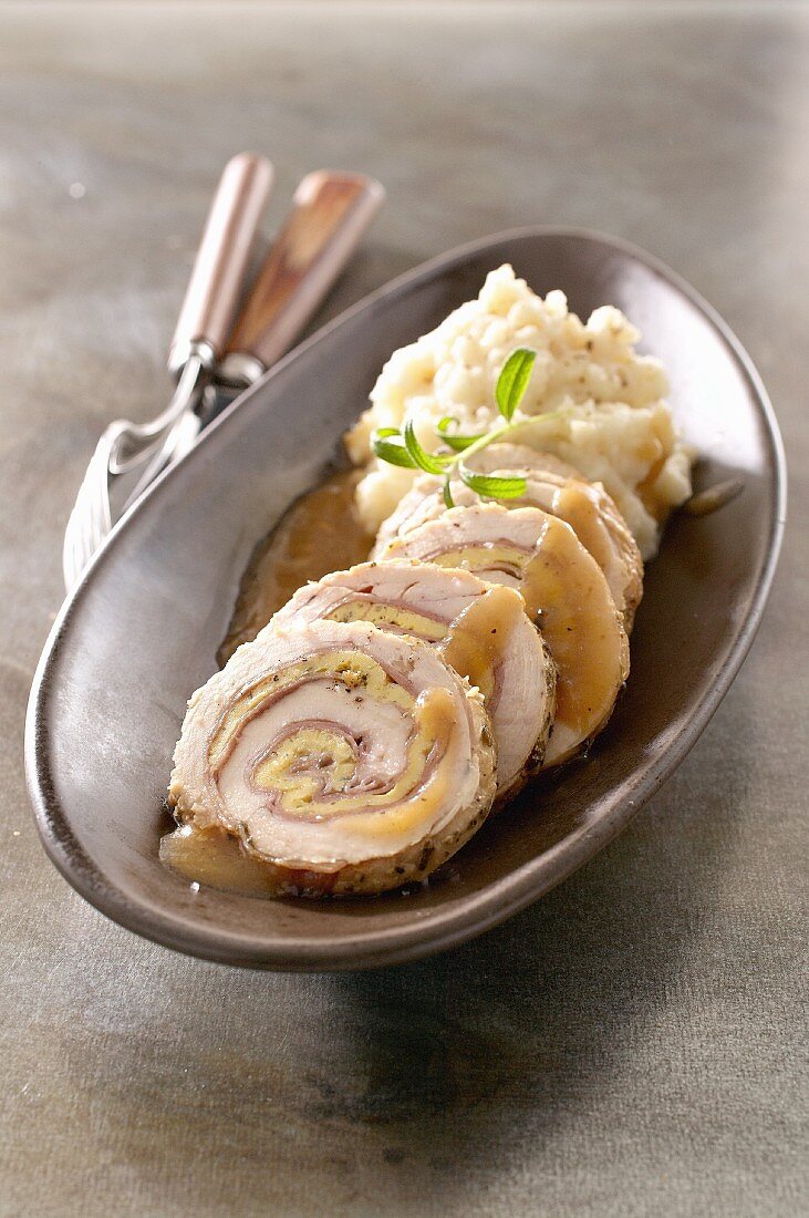 Slices of rolled roast turkey with mashed potato