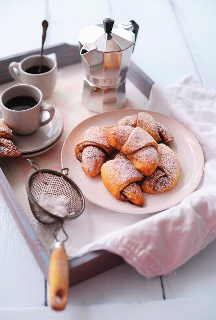 Croissants with icing sugar and coffee