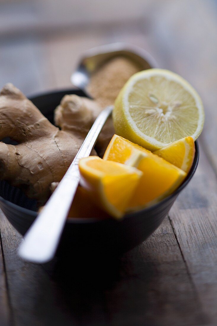 Fresh ginger root, orange wedges and half a lemon