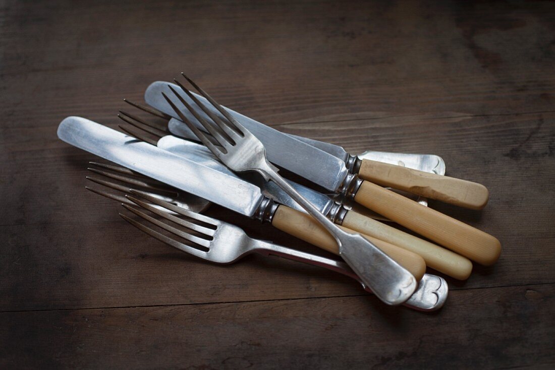 Knives and forks lying on a wooden surface