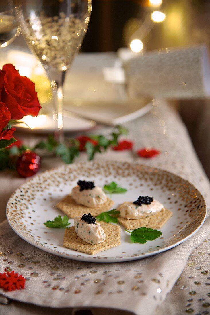 Crackers topped with smoked salmon and prawn mousse and caviar for Christmas dinner