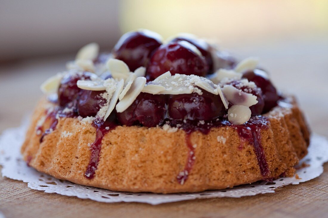 Individual cherry-topped cake with sliced almonds