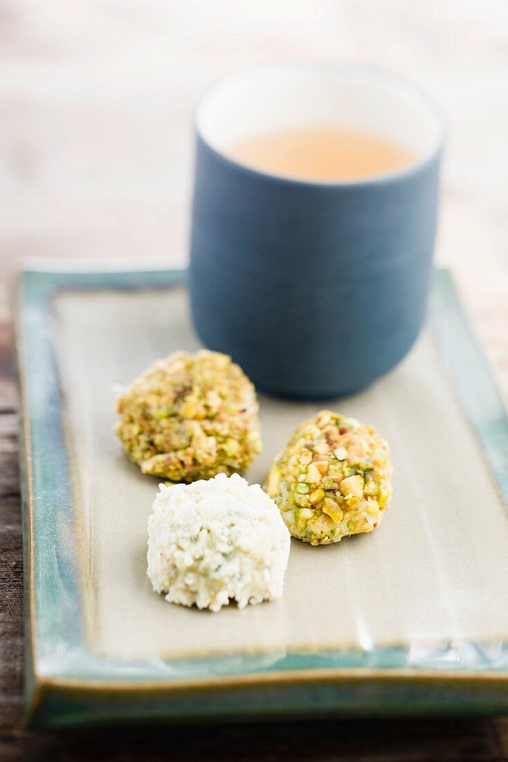 Chocolate truffles with pistachios and white chocolate, with a mug of tea