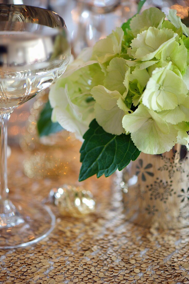 Weinglas und Hortensien auf festlichem Tisch