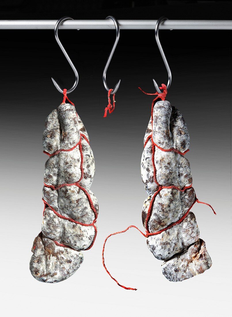 Air-dried salamis hanging from hooks