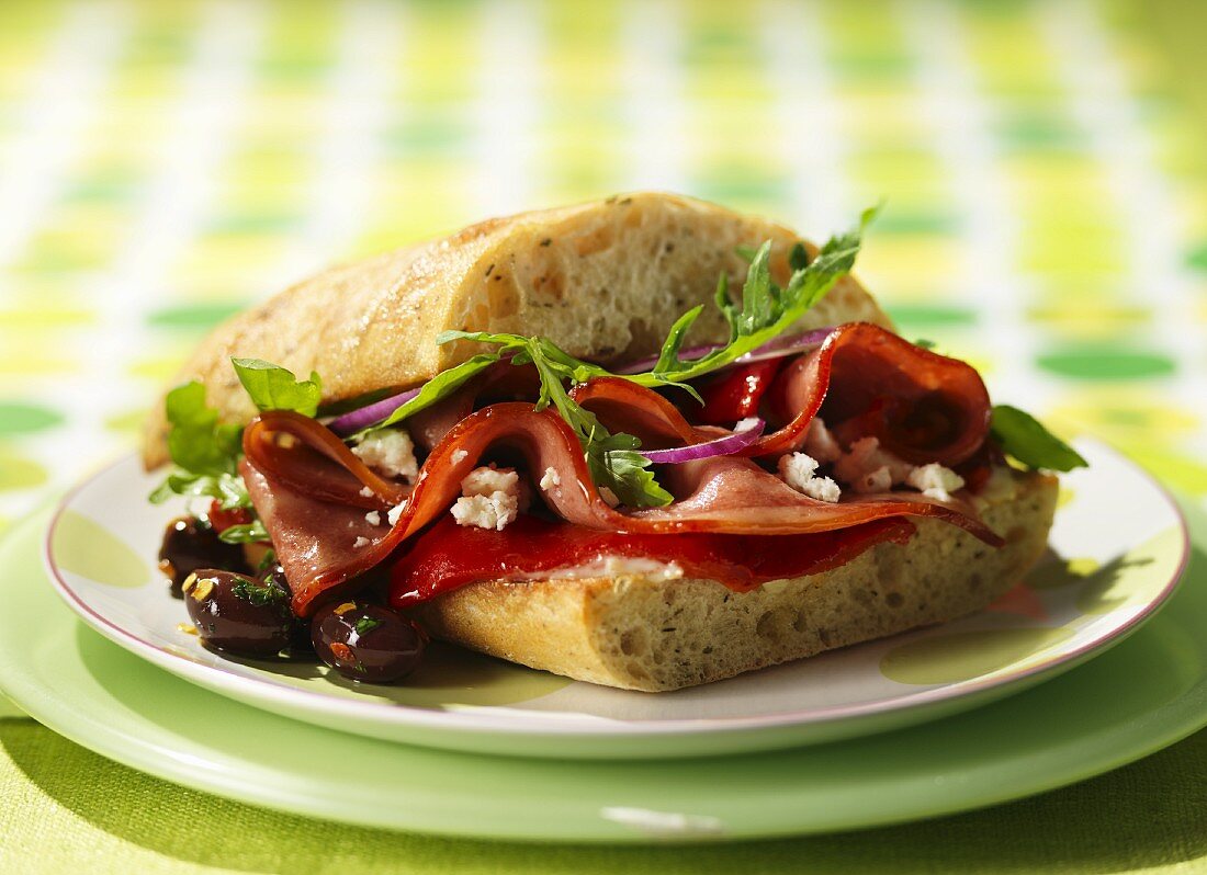Mediterraner Sandwich mit gegrillter Paprika, Schinken, Feta und Oliven